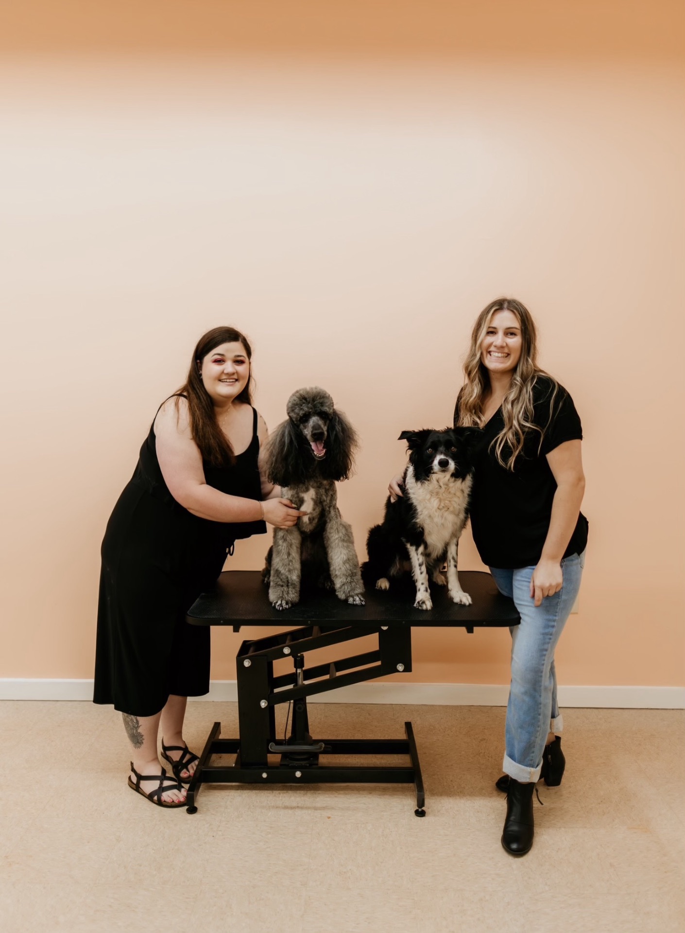 Liz and Sofia, co-owners and lead groomers of Peachy Paws Pet Spa, with two freshly groomed dogs